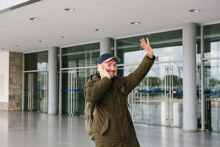imageye___-_imgi_61_107762386-a-young-male-tourist-at-the-airport-or-near-a-shopping-center-or-station-calls-a-taxi-or-talks-on-a.jpg